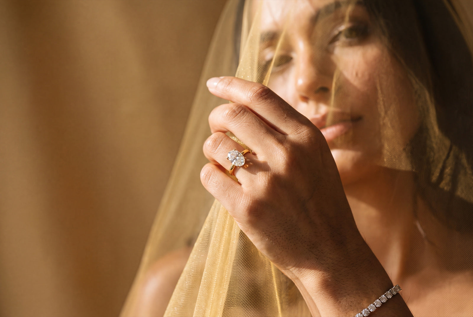 Margot Vane bride in a veil wearing an oval diamond engagement ring